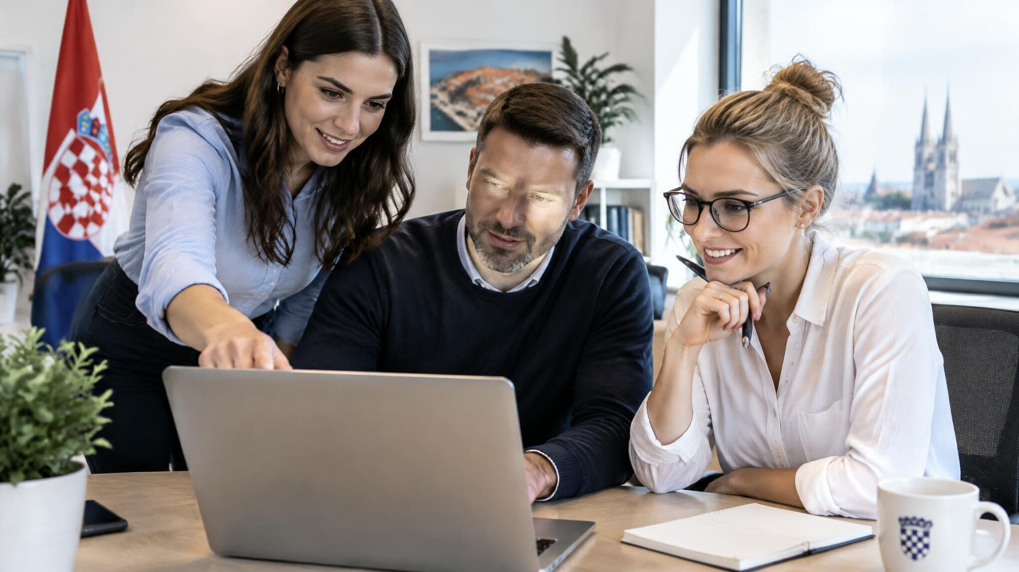 Small group of colleagues collaborating around a laptop